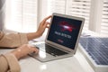 Fraud prevention security system. Woman using laptop at white table, closeup