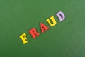 FRAUD word on green background composed from colorful abc alphabet block wooden letters, copy space for ad text. Learning english