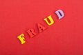 FRAUD word on red background composed from colorful abc alphabet block wooden letters, copy space for ad text. Learning Royalty Free Stock Photo