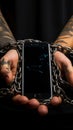 Fraudsters cuffed hands clutch phone, symbolizing addiction and illicit communications consequences Royalty Free Stock Photo