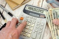 Fraudulence - word on calculator.Money in hand and office supplies