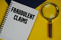 Fraudulent Claims text with magnifying glass on yellow background Royalty Free Stock Photo