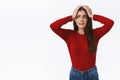 Freak-out alarmed young troublesome brunette girl in red sweater, grab head and stare in panic, standing worried or