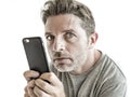 Freak and weird looking man using mobile phone watching something online in sick intense face expression in internet and social