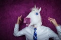 Freaky young man in comical mask stands on the purple background