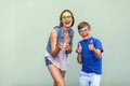 The freckled brother and sister in casual t shirts wearing trendy glasses and posing over light green background together. Royalty Free Stock Photo