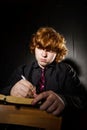 Freckled red-haired teenage boy reading book, education concept
