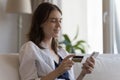 Woman holds credit card and cellphone buying goods online Royalty Free Stock Photo