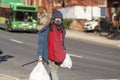 A long haired caucasian homeless man is walking in the street in downtown Frederick