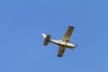 A white 1977 CESSNA 210M Fixed wing single engine private propeller airplane flying in clear sky