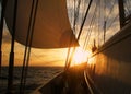 Fredom: Sailing with big sail, slow wind on the ocean towards a sunset at sea; give a sense of calm, relax, vacation and transport Royalty Free Stock Photo