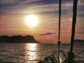 Fredom: Sailing with big sail, slow wind on the ocean towards a sunset at sea; give a sense of calm, relax, vacation and transport