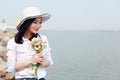 Free careless causual beauty by beach ocean lake river enjoy relax time in summer spring park smile on her face hold a flower Royalty Free Stock Photo