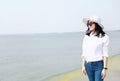 Free careless causual beauty enjoy good time next to a lake ocean river beach hold a bunch of flower wear a hat sit on a rock Royalty Free Stock Photo