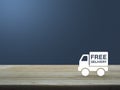 Free delivery truck icon on wooden table over blue background Royalty Free Stock Photo