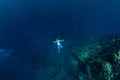 Free diver man in the depth make ring bubbles near shipwreck