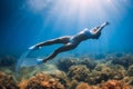 Free diver woman with mask and fins glides at deep ocean with sun rays. Freediving in tropical sea Royalty Free Stock Photo