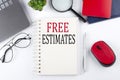 FREE ESTIMATES text on a notepad with laptop on the white background