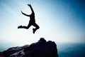 Female hiker jumping on sunrise seaside cliff edge Royalty Free Stock Photo