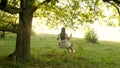 Free girl swinging on a swing on an oak branch in sun. Dreams of flying. Happy childhood concept. Beautiful girl in a