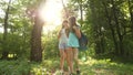 Free girls travelers with backpacks go through the thicket in the forest. children tourists travel in the summer park Royalty Free Stock Photo