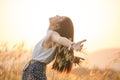 Free happy woman enjoying sunset. Beautiful woman in white dress embracing the golden sunshine glow of sunset with arms outspread Royalty Free Stock Photo