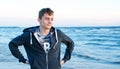 Free happy young man standing on the beach with his arms outstretched like a bird, feeling the warm wind looking into the distance Royalty Free Stock Photo