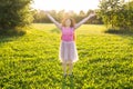 Free happy young woman raising arms watching the sun in the background at sunrise Royalty Free Stock Photo