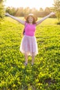 Free happy young woman raising arms watching the sun in the background at sunrise Royalty Free Stock Photo