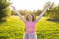 Free happy young woman raising arms watching the sun in the background at sunrise Royalty Free Stock Photo