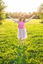 Free happy young woman raising arms watching the sun in the background at sunrise Royalty Free Stock Photo