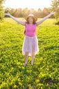 Free happy young woman raising arms watching the sun in the background at sunrise Royalty Free Stock Photo