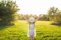 Free happy young woman raising arms watching the sun in the background at sunrise Royalty Free Stock Photo