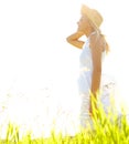 Free from hayfever. A beautiful young blonde woman standing in a meadow wearing a sunhat on a sunny day. Royalty Free Stock Photo