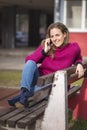 Free joyful woman using her cell phone in a park on a sunny day Royalty Free Stock Photo