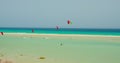 Free kiters on the ocean waves. Kitesurfing in the shallow blue transparent water. Paradise island. Sport activity