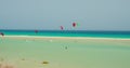 Free kiters on the ocean waves. Kitesurfing in the shallow blue transparent water. Paradise island. Sport activity Royalty Free Stock Photo