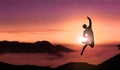 Free Man Jumps For Joy On The Top of Mountain Peak Above Clouds At Sunset. Young Successful Happy Person Jumping Royalty Free Stock Photo