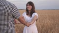 Free man and woman travel in field holding hands. Follow me, young happy couple running across golden wheat field Royalty Free Stock Photo