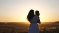 Free mom and little daughter are dancing in sunset. Mother and healthy baby in her arms in field. concept of a happy Royalty Free Stock Photo