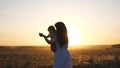 Free mom and little daughter are dancing in sunset. Mother and healthy baby in her arms in field. concept of a happy Royalty Free Stock Photo