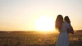 Free mom and little daughter are dancing in sunset. Mother and healthy baby in her arms in field. concept of a happy Royalty Free Stock Photo