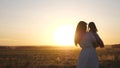 Free mom and little daughter are dancing in sunset. Mother and healthy baby in her arms in field. concept of a happy Royalty Free Stock Photo