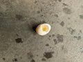 a free-range chicken egg with a hole in it with the egg yolk. on a gray cement floor Royalty Free Stock Photo