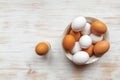 Free-range organic brown and white eggs in bowl and boiled egg in holder on vintage wooden background Royalty Free Stock Photo