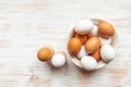 Free-range organic brown and white eggs in bowl and boiled eggs in holders on wooden background Royalty Free Stock Photo