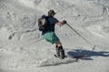 Free rider seen from behind wearing swim shorts and making a turn in Stowe Mountain resort in Vermont