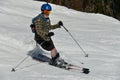 Free rider seen from side angle, wearing swim shorts and making a turn in Stowe Mountain resort in Vermont