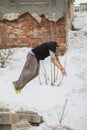 Free-run work out - teenager blonde hair guy training parkour jump flip in the snow covered park