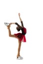 Portrait of little flexible girl, figure skater wearing stage attire posing isolated on white studio backgound. Concept